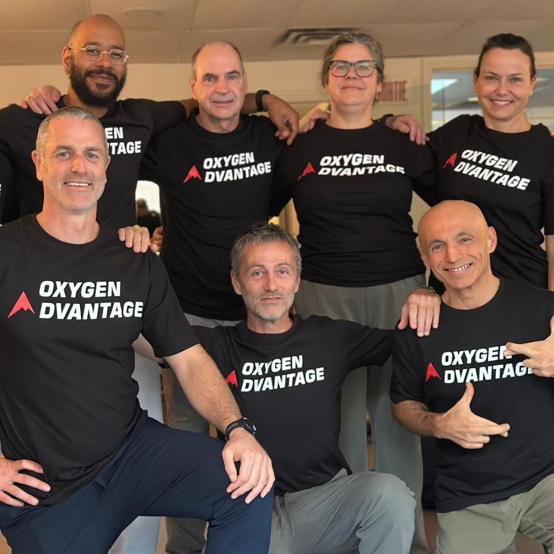 Group of people wearing Oxygen Advantage t-shirts in an indoor setting.