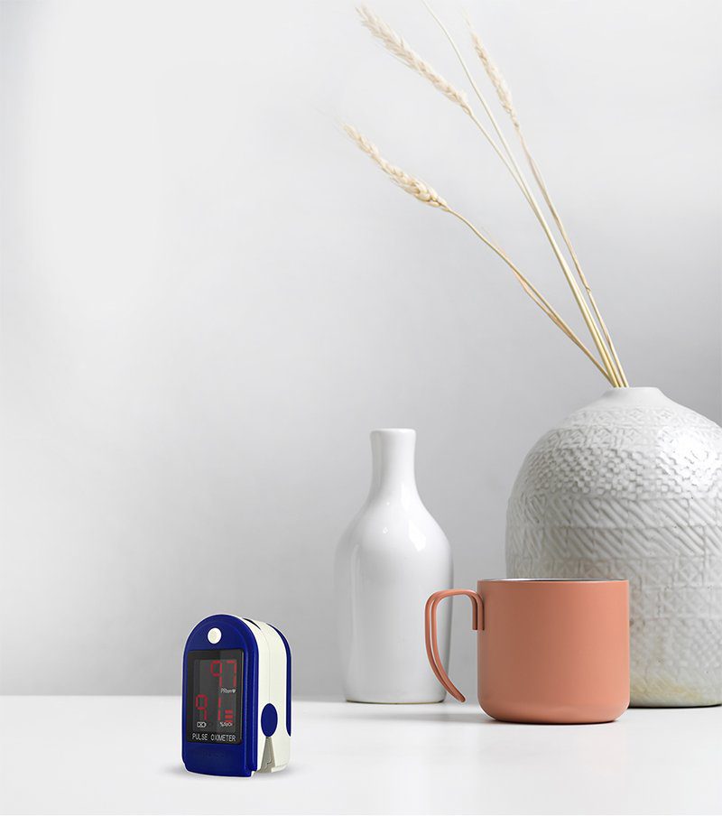 Oximeter on the table with vase and a cup