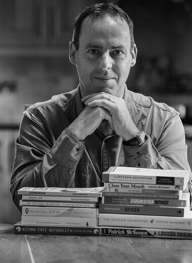 Patrick McKeown sitting with pile of books in front of him