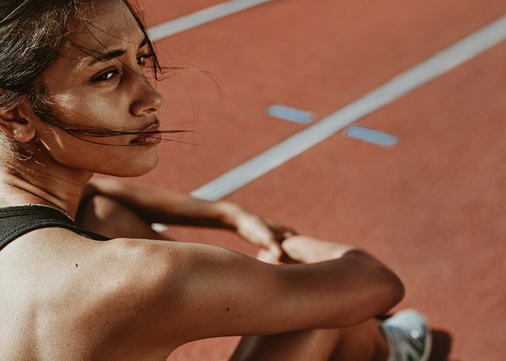 Girl athlete sitting and preparing for the race