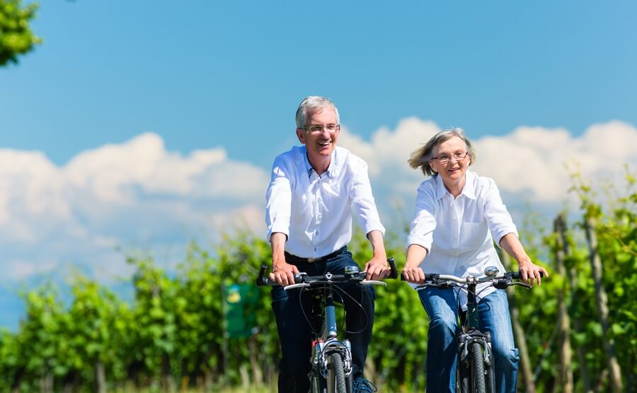 Older couple riding bikes in nature