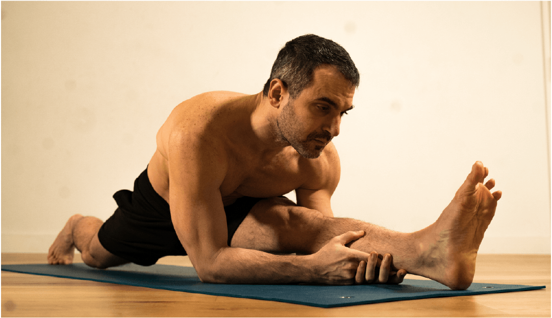Anastasis Tzanis - OA master instructor - in a yoga position - stretched legs